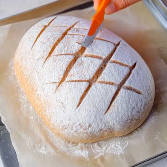 Scoring artisan bread dough before baking